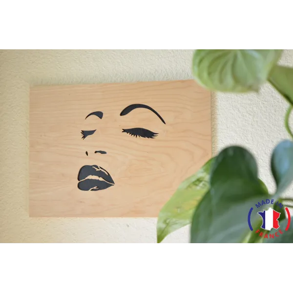 Painting of a woman's face chantourné in birch.